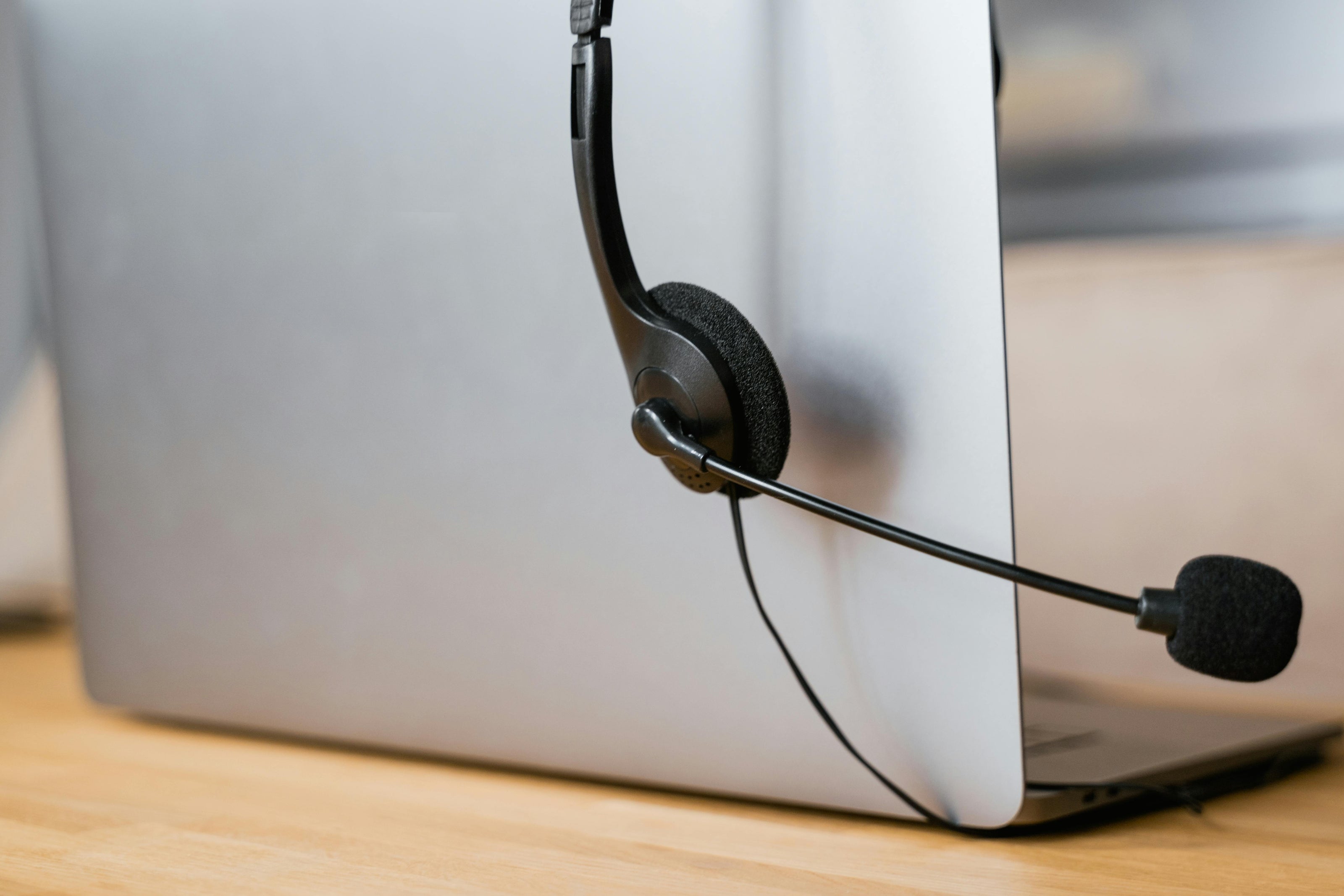 Laptop with a headset on a wooden surface